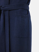 Close-up of a dark navy blue knit garment with a matching waist tie and a ribbed pocket, shown against a plain light background.