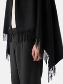 close up of a black fringed blanket and pants #color_black