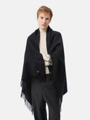 front side of a man wearing a black fringed blanket over a white sweater #color_black