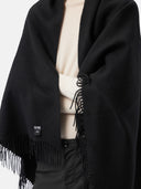 close up of a black fringed blanket with a small label "GOBI" by person #color_black