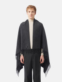 Man wearing a dark gray blanket with fringes on a white background #color_charcoal