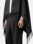 close up of a dark gray fringed blanket and black pants #color_charcoal