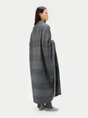 back view of a woman wearing a dark gray blanket on a white background #color_charcoal