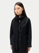 woman wearing a black double breasted coat and a scarf. #color_black