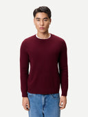 Front side of a man wearing a burgundy sweater and blue jeans on a white background #color_zinfandel