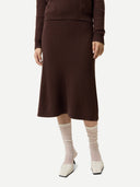 Person wearing a brown knit skirt and sweater with white shoes and socks on a white background #color_deep-mahogany