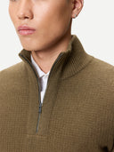 Close-up of a person wearing a brown half-zip sweater over a white shirt. #color_cub