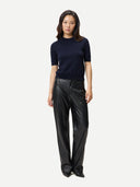 front view of a woman wearing a black cashmere top and black leather pants on a white background #color_navy-blazer
