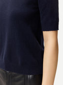 close up of a dark navy short-sleeve sweater worn by a person on a white background #color_navy-blazer