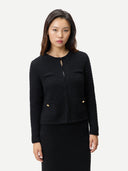 Woman wearing a black textured cardigan and matching knit skirt on a white background #color_black