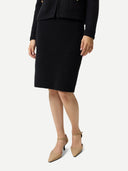 Person wearing a black ribbed skirt with a matching top on a white background #color_black