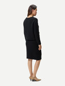 Back view of a woman wearing a black outfit on a white background #color_black