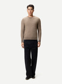 Man wearing a beige sweater and black pants on a white background #color_taupe