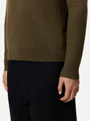 Close-up of a person wearing a brown sweater and black pants on a white background #color_cub