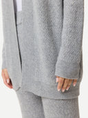 Close up of a gray cable knit cardigan worn by a person on a white background #color_high-rise
