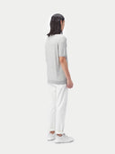 back view of a man standing a gray polo shirt and white pants #color_vapor-blue