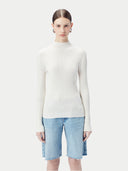 close up front view of Person wearing a white ribbed sweater and light blue denim shorts on a white background #color_whisper-white
