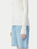 close up bottom side of a white long sleeve ribbed sweater and shorts #color_whisper-white