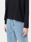 close up bottom side of a black sweater and jeans #color_black