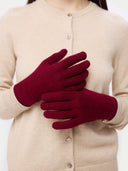 Person wearing red gloves with a beige cardigan on a white background #color_bordeaux