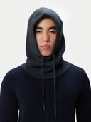 Person wearing a dark gray knitted hoodie against a white background #color_charcoal