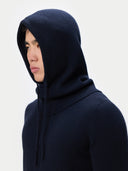 Person wearing a dark blue knitted hood against a light gray background #color_navy-blazer