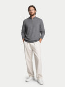 front view of a man wearing a gray sweater with a quarter zip and white pants on a light gray background #color_dim-gray