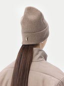 back view of a beige beanie with a small brand label and jacket #color_taupe