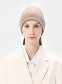 woman wearing a beige beanie with white coat over a shirt #color_taupe