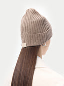 back view of a beige rib knit beanie with a small brand logo label #color_taupe