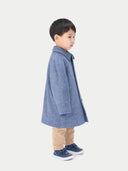 A child wearing a blue cashmere coat with a round neckline, button details, and a herringbone pattern on the collar and cuffs.  #color_english-manor