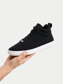 Black high-top sneaker held in a hand against a white background #color_black