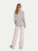 back view of a person wearing a light gray turtleneck sweater and beige pants on a white background #color_chateau-gray