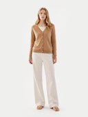 front view of a woman wearing a brown cardigan and white pants on a white background #color_sheepskin