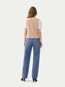 front view of a woman wearing a beige sleeveless sweater and blue jeans on a white background #color_beige