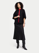 front view of a woman wearing a black outfit with a red accent on a white background #color_charcoal