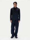 A man modeling a dark navy blue traditional Chinese jacket and matching cargo pants against a plain light gray background.