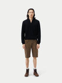 front view of a man wearing a black half-zip cashmere sweater with long sleeves and brown shorts, standing against a plain background. #color_black