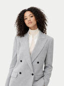 Woman wearing a gray blazer with black buttons on a white background #color_vapor-blue