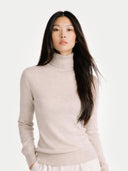 close up of a woman wearing a beige turtleneck sweater on a white background #color_warm-grey