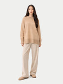 Woman wearing a beige sweater and pants on a white background #color_beige