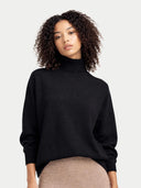 Woman wearing a black turtleneck sweater against a plain background #color_black
