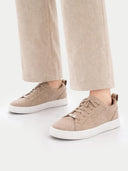 Beige sneakers worn with beige pants on a white background #color_taupe