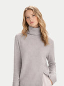 Woman wearing a light gray turtleneck sweater on a white background #color_chateau-gray