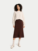 Woman wearing a cream sweater and brown skirt on a white background #color_deep-mahogany