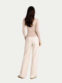 back view of a woman wearing a beige outfit with wide-leg pants on a white background #color_beige