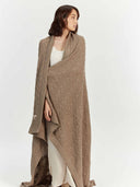 woman wrapped in a long beige blanket #color_taupe