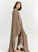 side view - woman standing wrappd in a long blanket #color_taupe