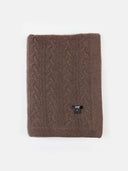 A brown cable knit blanket with a textured pattern, folded neatly and displayed against a neutral background.