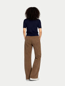 back view of a woman wearing a navy short sleeve sweater and brown pants on a white background #color_navy-blazer